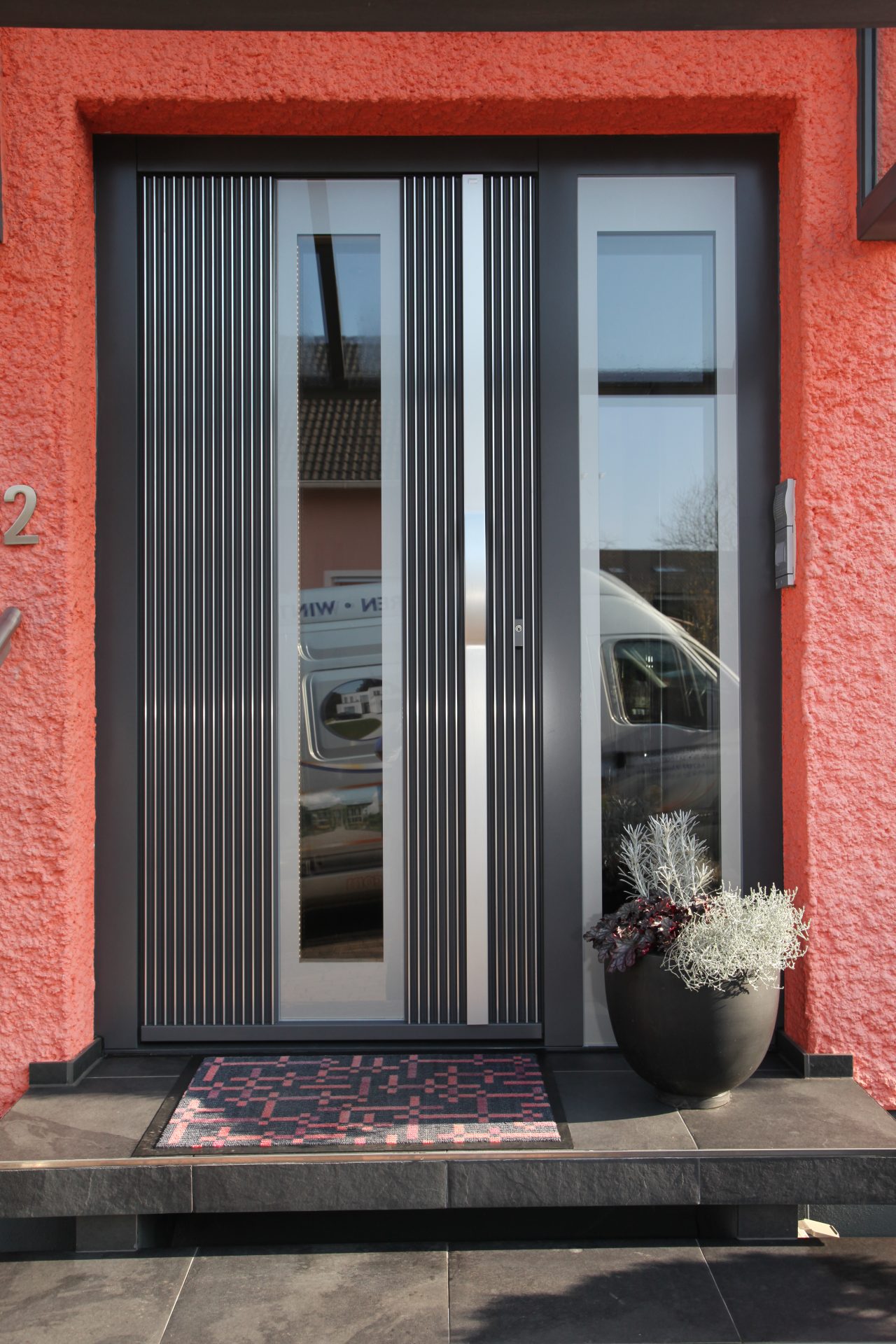 Moderne graue Haustür mit zwei Glaselementen