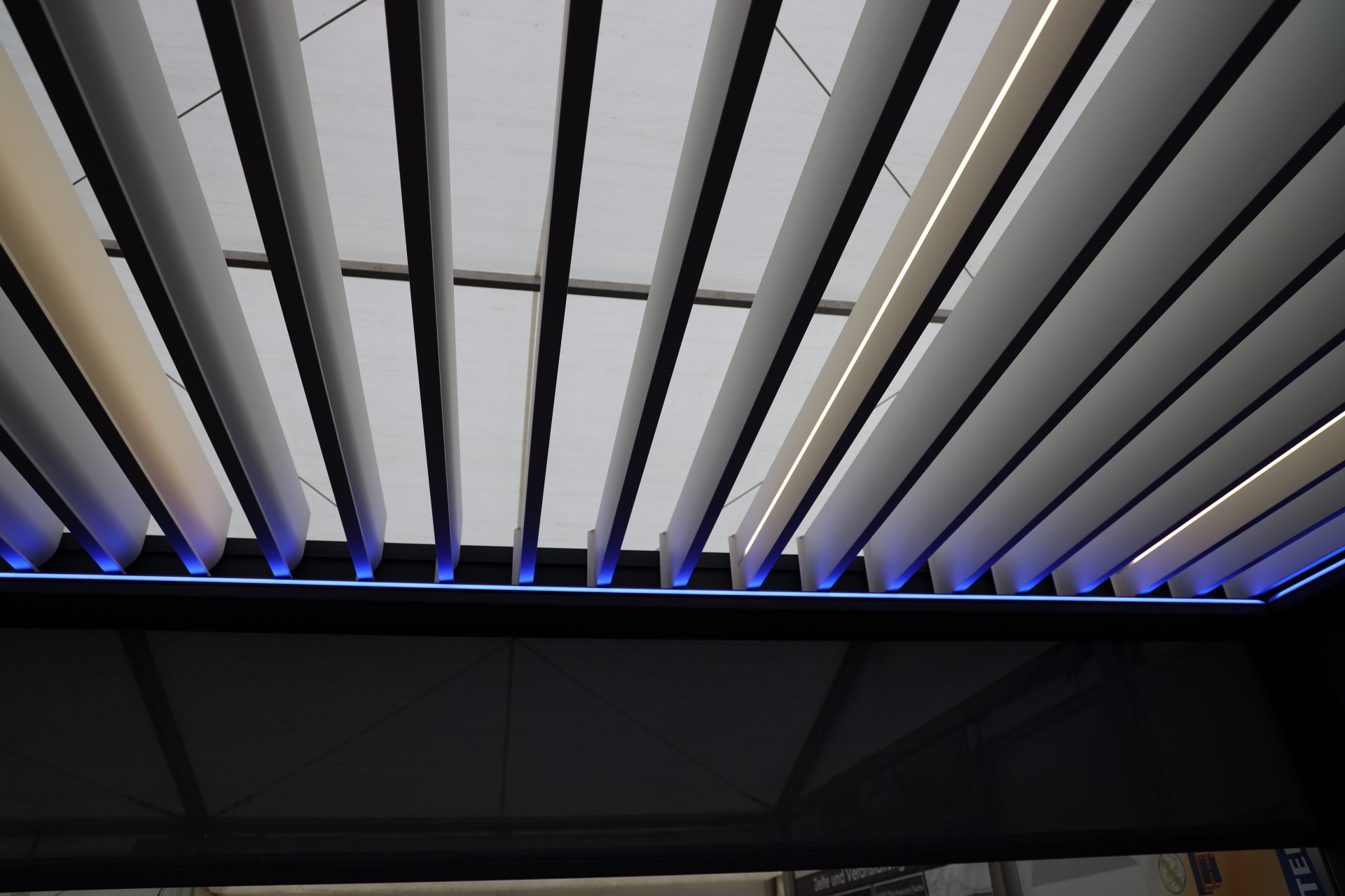 Modernes Lamellendach mit integrierter LED Beleuchtung und geöffneten Lamellen